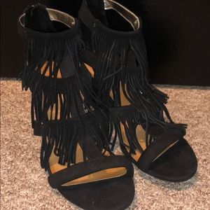 Black fringed wedged heels.